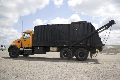Branded skip hire vehicle delivering a skip on site